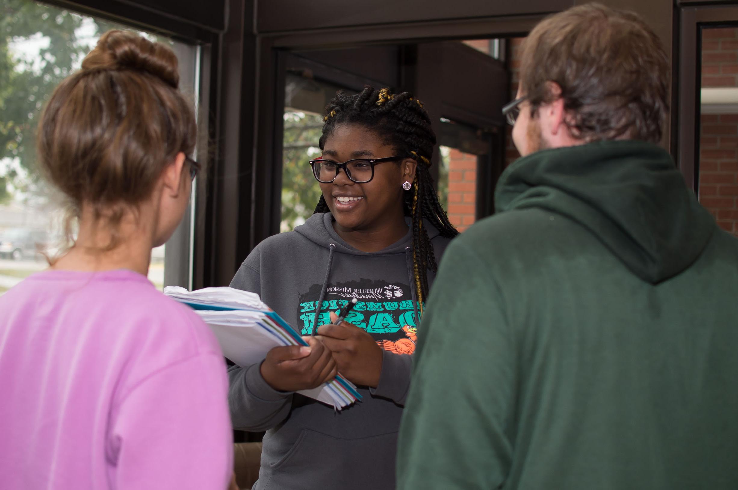 A behavioral sciences student interviewing two other students